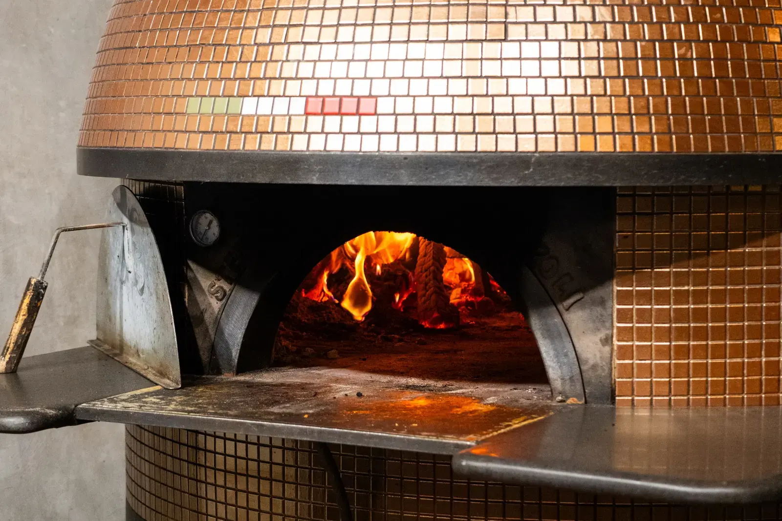Four à bois napolitain en mosaïque cuivrée, feu allumé