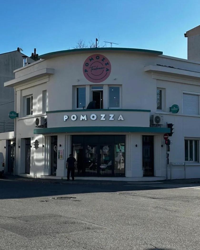 La façade art déco de POMOZZA Toulouse, avenue Frédéric Estèbe, avec son enseigne ronde rose